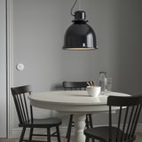Moderner Essbereich mit großer schwarzer SVARTNORA Pendelleuchte, kontrastierendem weißem Tisch und schwarzen Stühlen. Minimalistisches, stilvolles Design.