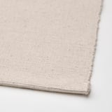 Nahaufnahme eines Tischläufers aus natürlicher Baumwolle, der Textur und Nähte zeigt.
