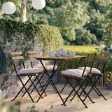 Kleine Terrasse mit Holztisch, 4 Stühlen, Kissen. Umgeben von viel Grün, gemütliche Sitzgelegenheiten im Freien.