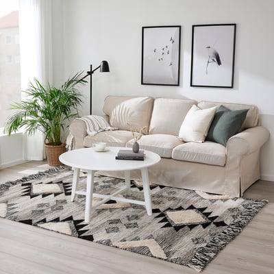 Der beige Teppich TANNISBY im marokkanischen Stil passt gut unter ein neutrales Sofa und verleiht dem Wohnzimmer eine weiche Textur.