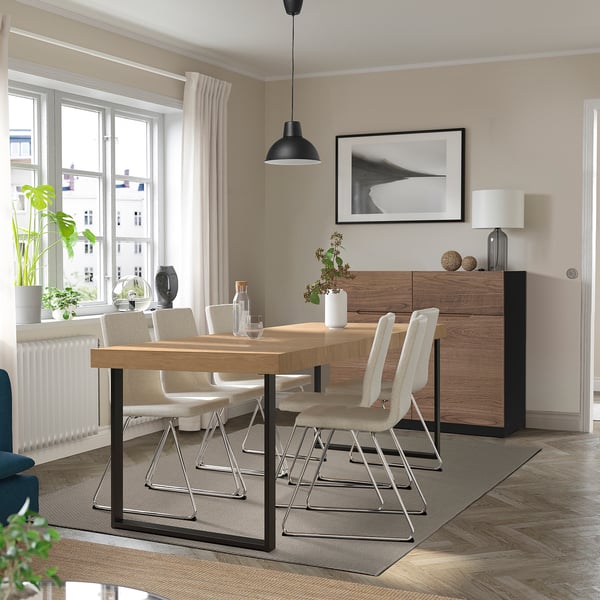 Moderner Essbereich mit Tisch aus TARSELE Eiche, Platz für 4-6 Personen, erweitert. Metallbeine, minimalistische Kunst, weiße Vorhänge.