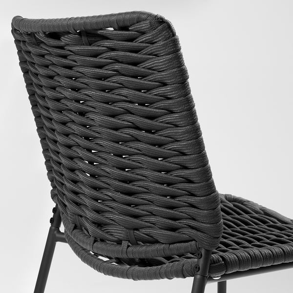 Schwarzer Outdoor-Stuhl aus Korbgeflecht mit geflochtenem Sitz und Rückenlehne, getragen von vier Metallbeinen.