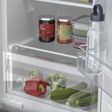 Kühlschrank mit verstellbaren Regalen; Gemüse und Gläser ordentlich aufbewahrt.