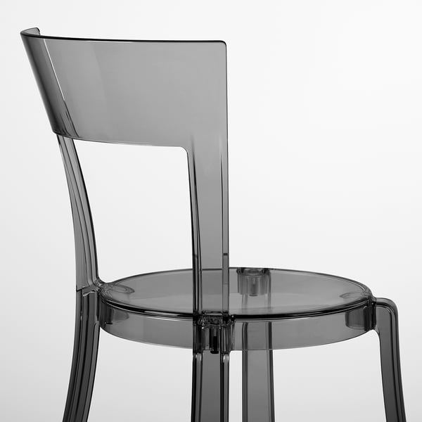 Ein moderner, durchsichtiger Kunststoffstuhl mit gebogener Rückenlehne und rundem Sitz, der ein elegantes Design und hochwertige Materialien zeigt.