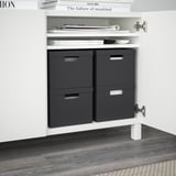 Weißer Schrank mit schwarzen Aufbewahrungsboxen, oberes Regal mit Büchern; TJENA-Serie.