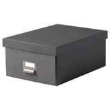 Eine TJOG-Aufbewahrungsbox in Dunkelgrau mit einem Etikettenhalter aus Metall auf einer Seite. Es ist rechteckig und aus recyceltem Karton gefertigt.