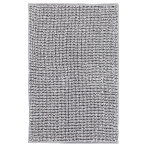 Eine graue TOFTBO-Badematte, rechteckig, mit einem weichen, strukturierten Design. Es besteht aus recyceltem Polyester.