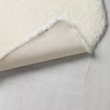 Okay Teppichrückseite mit TOFTLUND Anti-Rutsch-Unterlage auf Holzboden.