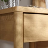 Nahaufnahme einer Holzmöbelecke mit glatter, heller Eichenoberfläche und robuster Tischlerarbeiten.