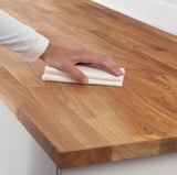 Tragen Sie das Tuch von Hand auf die Holzoberfläche auf und behandeln Sie es mit Öl, um es zu schützen und zu glänzen.