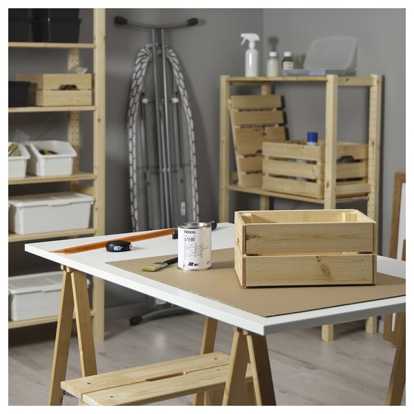 Organisierter Arbeitsbereich mit TRIXIG Holzbehandlungsöl auf Tischen, Holzkisten und Aufbewahrungseinheiten.