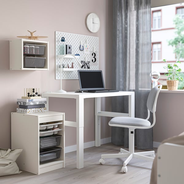 TROFAST-Regal mit Laptop, Büchern, Dekor in der Nähe des Schreibtisches.