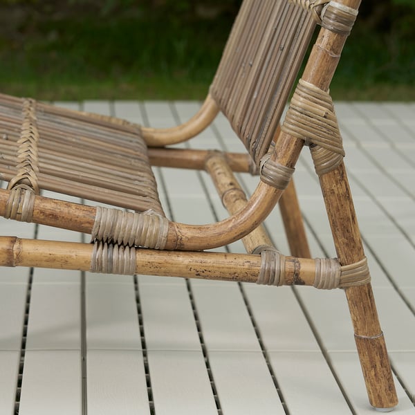Korbstuhl auf der Terrasse; Handgeflochtenes Naturrattan, witterungsbeständig, langlebige Verarbeitung.