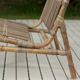 Korbstuhl auf der Terrasse; Handgeflochtenes Naturrattan, witterungsbeständig, langlebige Verarbeitung.