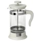 Option: Eine weiße French-Press-Kaffeemaschine mit einem durchsichtigen Glasgefäß, einem Netzfilter aus Edelstahl und einem Deckel, einem Griff und einem Sockel aus Kunststoff.