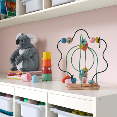 Buntes UPPSTÅ Holzspielzeug mit beweglichen Blättern und Blumen. Neben Koala & Blöcken im Regal.