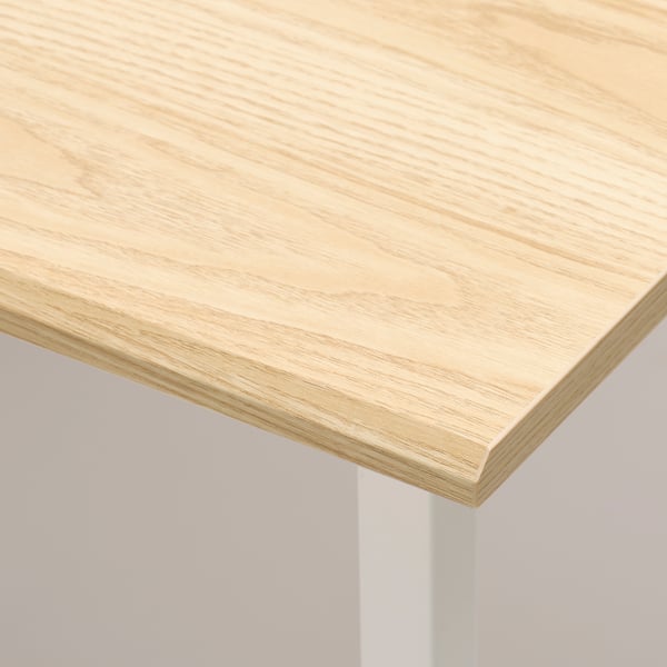 Nahaufnahme einer glatten, hellen Tischplattenecke aus Holz, die eine hochwertige Verarbeitung zeigt.