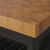 Nahaufnahme einer robusten Arbeitsplatte aus Hirnholz aus Eiche auf der Kücheninsel. Zeigt handwerkliche Qualität und natürliche Holzmaserung.
