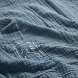 Weicher blauer Wickelbezug aus Bio-Baumwolle, gesticktes Katzendetail, hochwertige Textur.