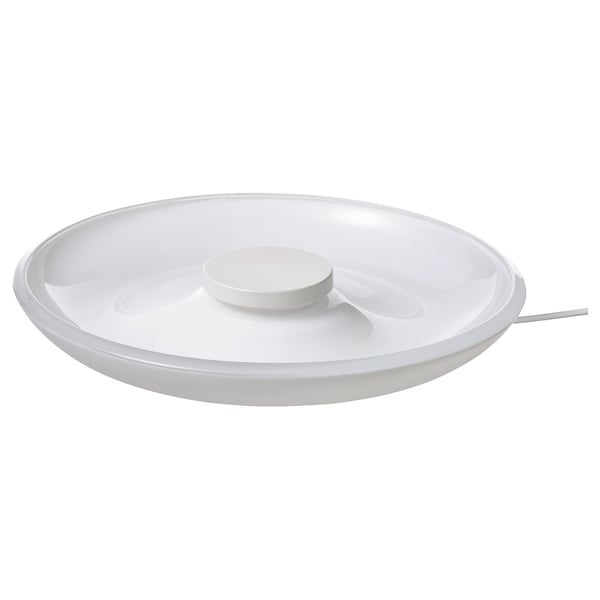 Ein weißes kabelloses Ladegerät von VÄSTMÄRKE mit Glasplatte und Polycarbonat-Sockel, Schüsselform und integrierter Beleuchtung.