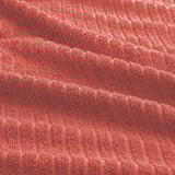 Lebendiges, weiches und strukturiertes rotes Handtuch; Frottee mit absorbierender Qualität, dargestellt in einem wellenförmigen Muster.