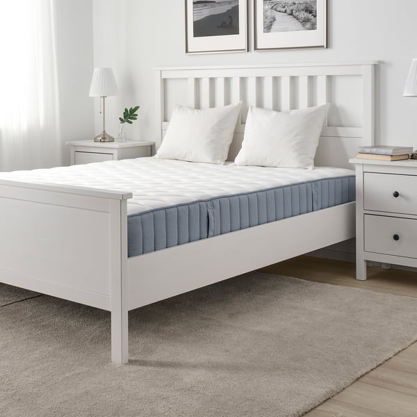 Elegantes Bett mit weißer Matratze, Nachttischen, Kunst, grauem Teppich.