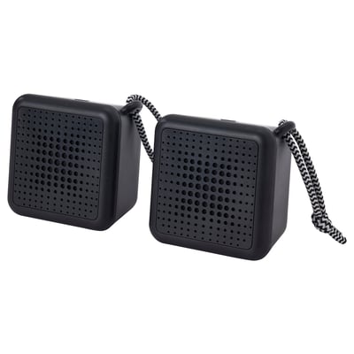 Zwei schwarze, quadratische VAPPEBY-Lautsprecher, wasserdicht, mit koppelbarer Bluetooth-Konnektivität, die mit einem Kabel verbunden sind.