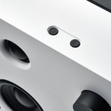 Draufsicht auf schlanken, modernen Bluetooth-Lautsprecher mit kreisförmigen Bedienelementen, glatter Oberfläche und schwarzen Akzenten.