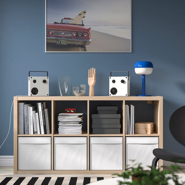 Modernes Zimmer mit blauer Wand, rotem Autofoto, Bücherregal, VAPPEBY-Lautsprechern.
