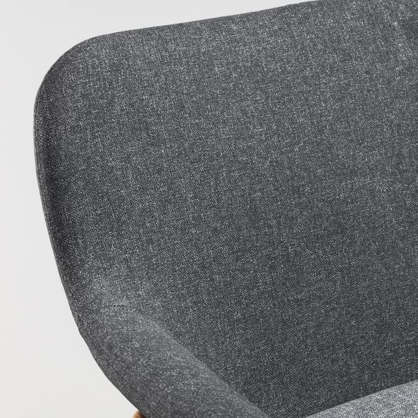 Eine Nahaufnahme eines modernen, grauen Polstersessels, der seinen glatten Stoff und sein schlankes Design zur Geltung bringt. VEDBO.