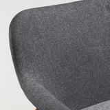 Eine Nahaufnahme eines modernen, grauen Polstersessels, der seinen glatten Stoff und sein schlankes Design zur Geltung bringt. VEDBO.