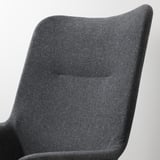 Dunkelgrau gepolsterter Stuhl mit schlanken, stützenden Kurven. Hohe Rückenlehne für Lendenwirbelstütze, weicher Stoffbezug. Elegantes Profil für moderne Einrichtung.