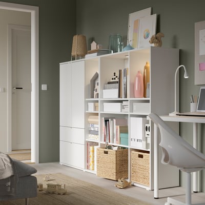 Grünes Wohnzimmer mit Bücherregal und Spielzeug.