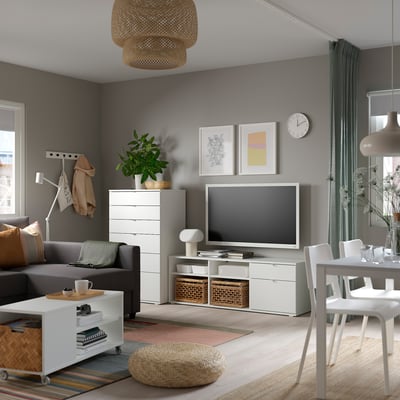 Modernes Wohnzimmer mit grauen Wänden, einem grauen Sofa, einem weißen TV-Ständer und Dekorationsgegenständen.