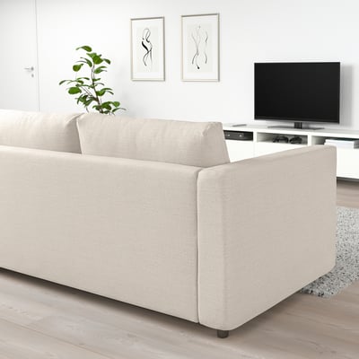 Modernes Wohnzimmer mit beigem VIMLE-Schlafsofa, Flachbildfernseher, minimalistischer Kunst und Pflanzen.