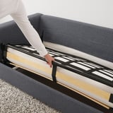 Eine Person zieht den Bettrahmen von einem VIMLE-Sofa heraus und gibt den Blick auf eine dicke Matratze frei, die für bequemes Schlafen sorgt.