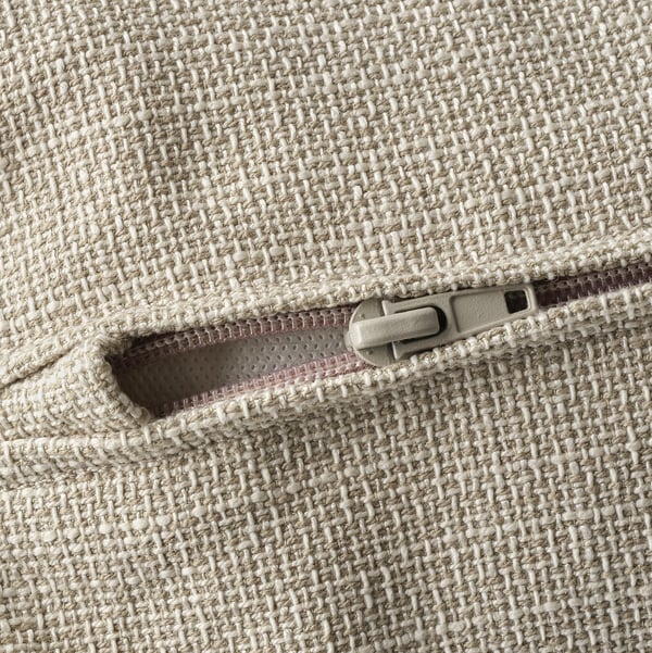 Nahaufnahme des Reißverschlusses auf einem hochwertigen, strukturierten beigen Sofa