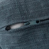 Nahaufnahme eines strukturierten, grauen Reißverschlusses auf einem hochwertigen Sofa, das strapazierfähigen Stoff und präzise Verarbeitung zeigt.