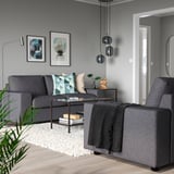 Modernes Wohnzimmer mit VIMLE-Sofa, geometrischen Kissen, Couchtisch, Hängelampen und abstrakter Kunst.