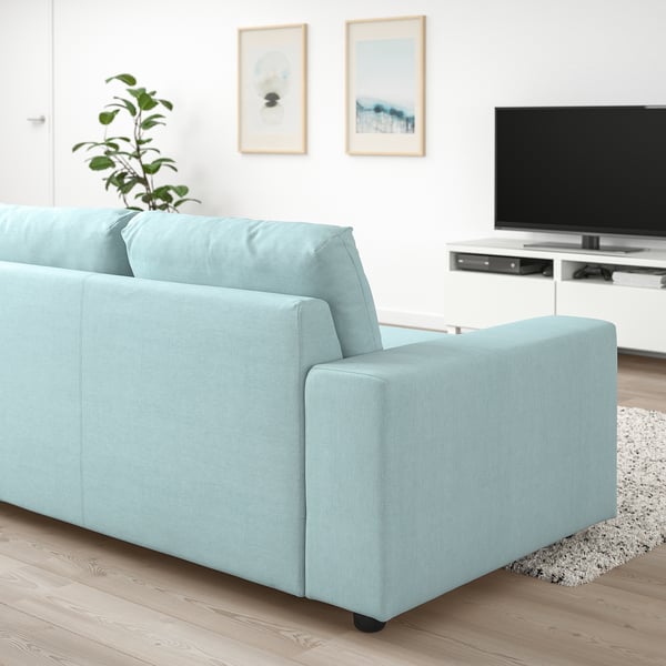 Blaues VIMLE-Sofa im modernen Wohnzimmer mit TV, Pflanze und Kunstwerken.