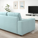 Blaues VIMLE-Sofa im modernen Wohnzimmer mit TV, Pflanze und Kunstwerken.