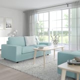 Modernes blaues VIMLE-Sofa in ruhigem Wohnzimmer, Couchtisch in der Mitte, große Fenster.