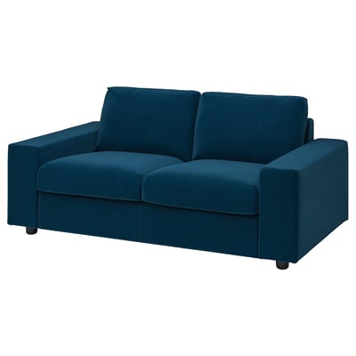 Ein VIMLE Sofa aus blauem Samt mit einem schlanken, modernen Design. Das Sofa hat eine rechteckige Form und ist mit weichem, recyceltem Stoff bezogen.