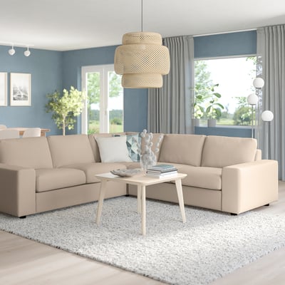 Beige VIMLE Sektion im Wohnzimmer mit Couchtisch, Pendelleuchte, blauen Wänden, grauen Vorhängen und großem Fenster mit Blick ins Grüne.