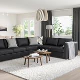 Modernes Wohnzimmer mit schwarzem VIMLE-Sektionssofa, zwei Couchtischen und weißem Teppich.