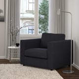 Modernes Wohnzimmer mit VIMLE Sessel, Fenster, Teppich, Beistelltisch mit Kirschblüten.