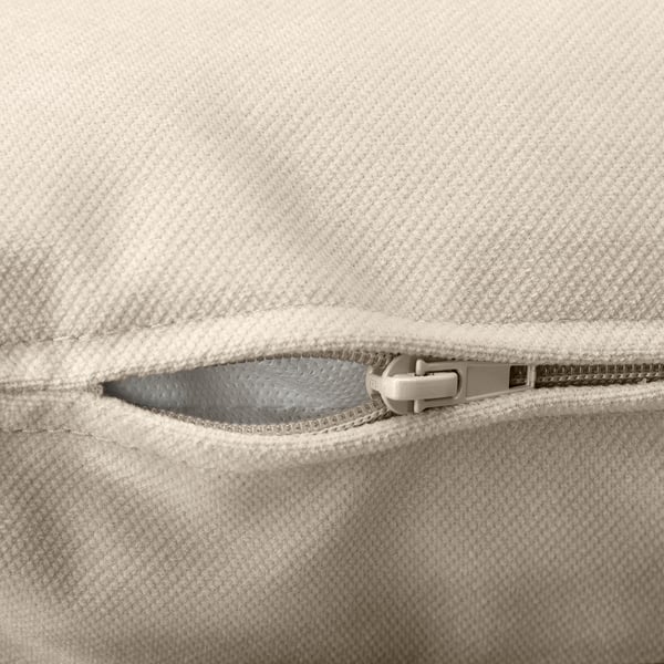 Nahaufnahme des beigefarbenen gepolsterten Reißverschlusses des Sofas, der hochwertige Nähte und Design zeigt.