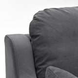 Nahaufnahme eines weichen, grauen Sofas mit weichen, strukturierten Kissen, die Komfort und Qualität betonen.