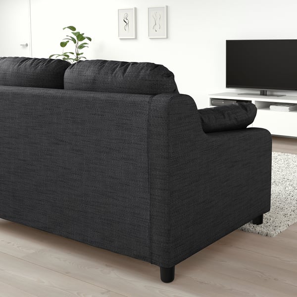 Modernes Wohnzimmer mit großem schwarzen VINLIDEN-Sofa, TV und Dekor.