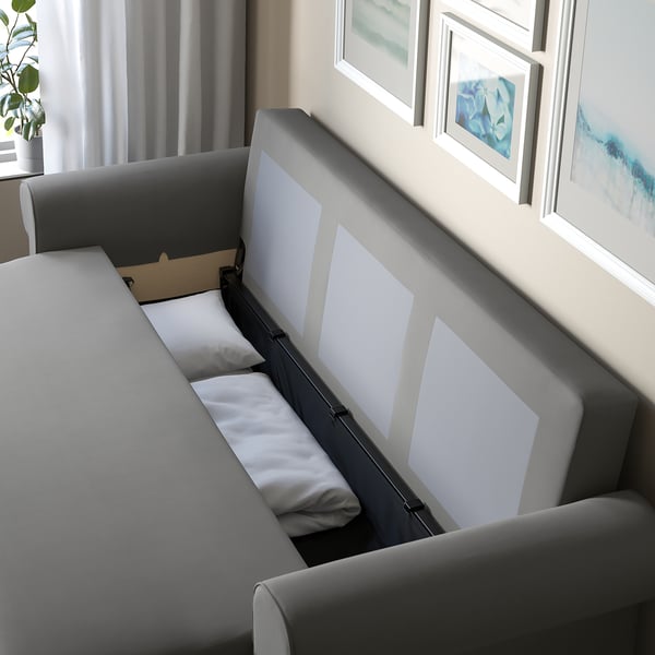 Schlafsofa mit leicht umwandelbarer Rückenlehne, Stauraum und gemütlichen Kissen.
